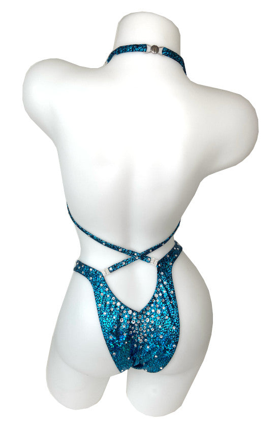 JW Couture custom Figure & Women's Physique competition suit. Crystal rhinestones fade downwards on the bottoms. Crystal clips attach the straps in the back, on turquoise fabric. Handmade in Canada.